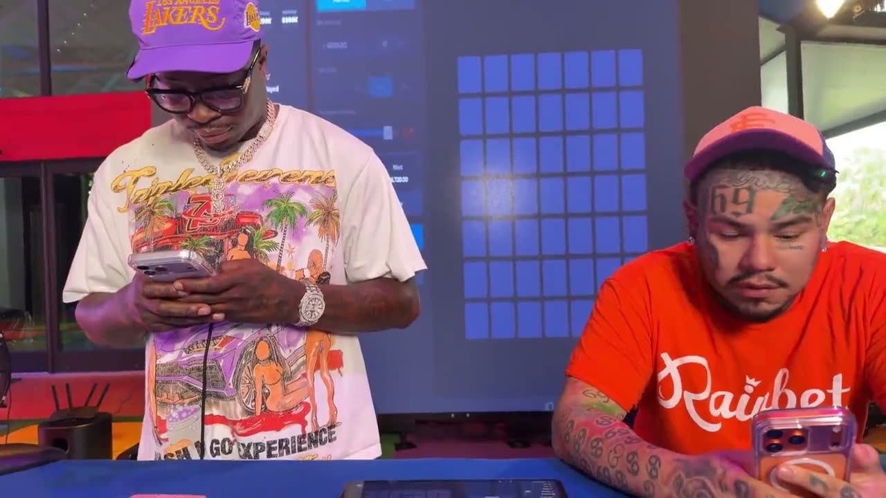 Two creators on their phones during a live Rainbet stream